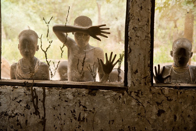 Bambini della tribù Kara che guardano attraverso le finestre, Omo Valley, Ethiopia, 2013 (Children from Kara tribe look through windows, Omo Valley, Ethiopia, 2013) ©Steve McCurry
