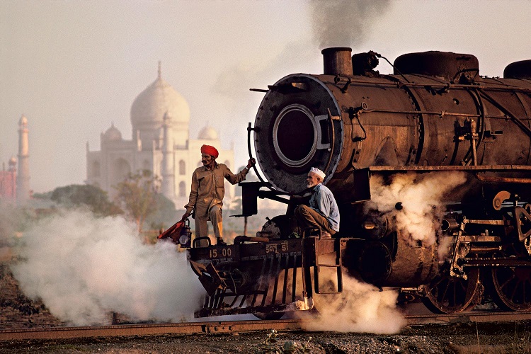 Operai su una locomotiva a vapore, India, 1983 (Workers on a steam locomotive, India, 1983) ©Steve McCurry