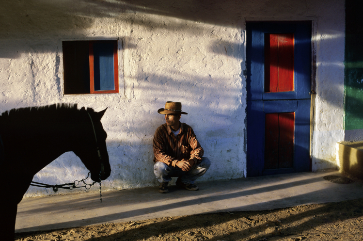 A man crouches against a wall - Steve McCurry