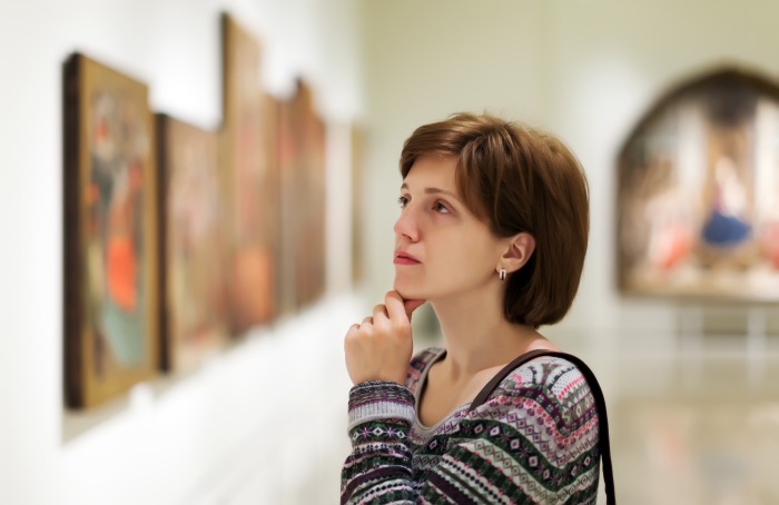 Female visitor looking pictures in art gallery