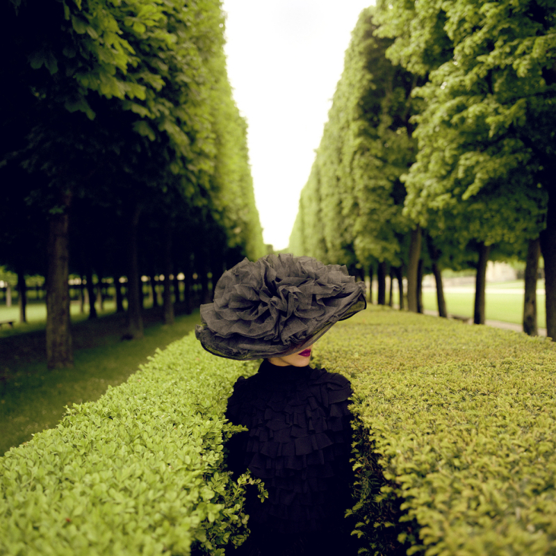 Rodney Smith Woman with Hat between Hedges
